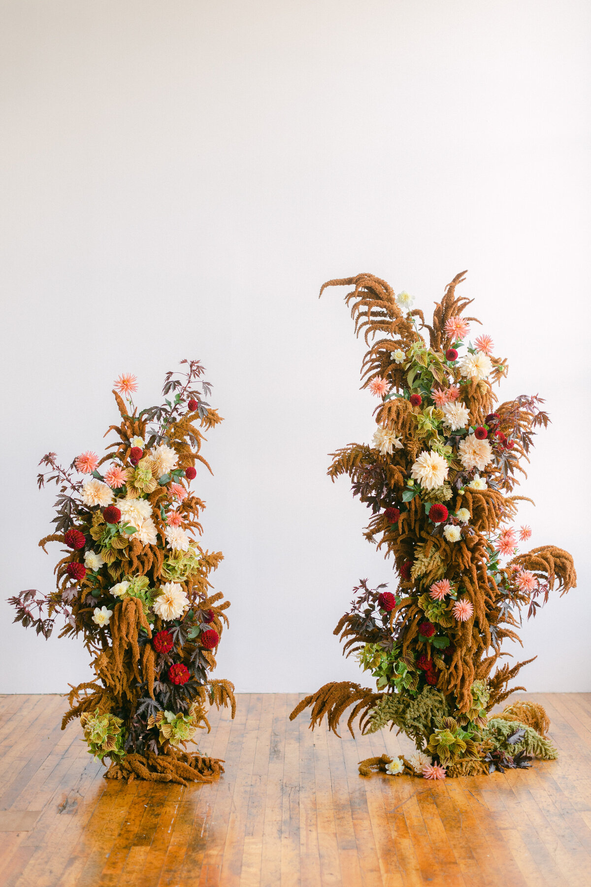 Two standing ceremony arrangements of lush and woodsy autumn flowers for a Montreal wedding.