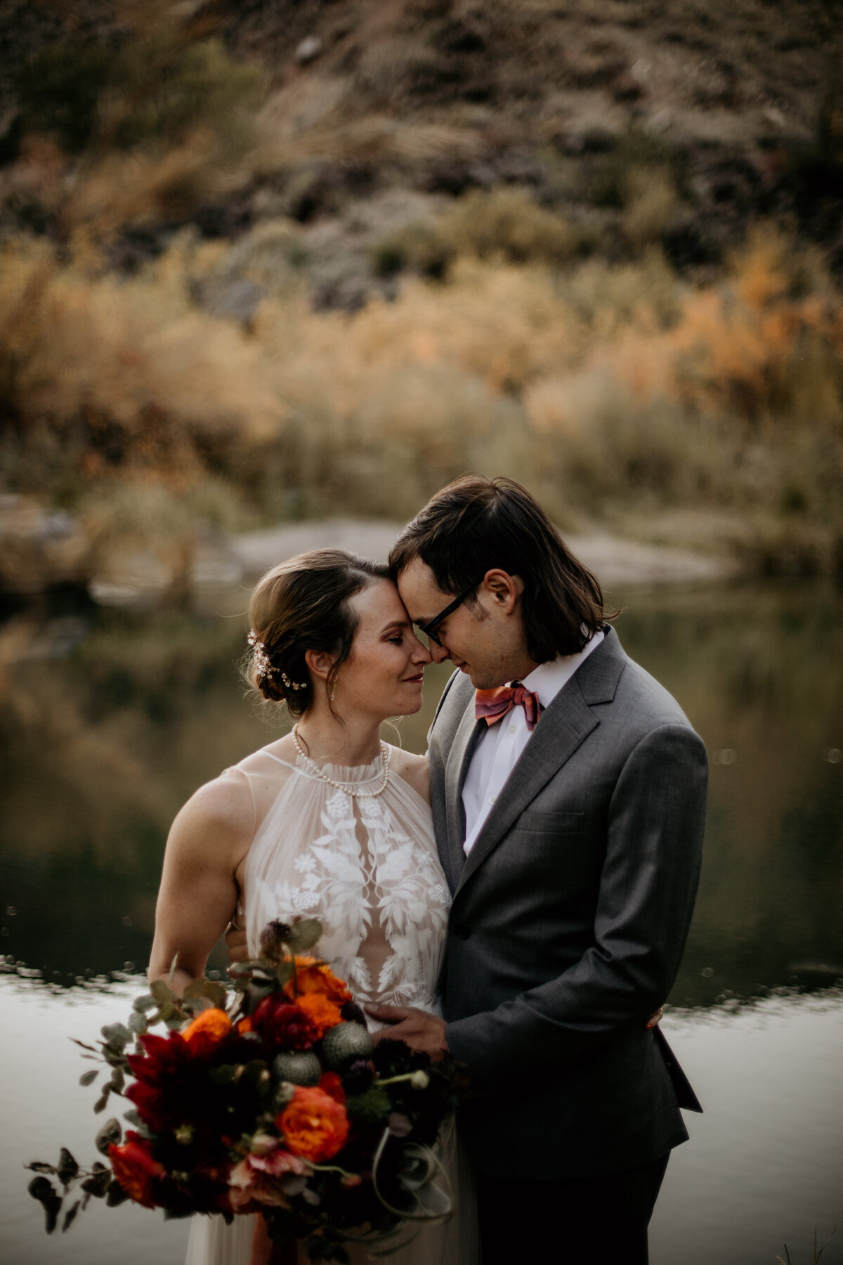 bride and groom with foreheads together in front of the Rio Grande