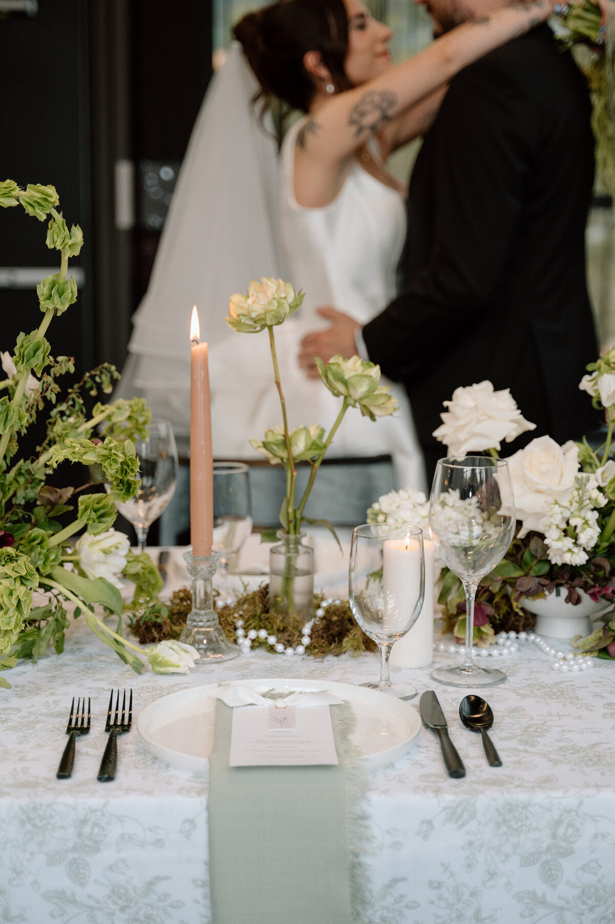 Elegant Banff wedding reception tablescape with white florals, candles, and natural greens.
