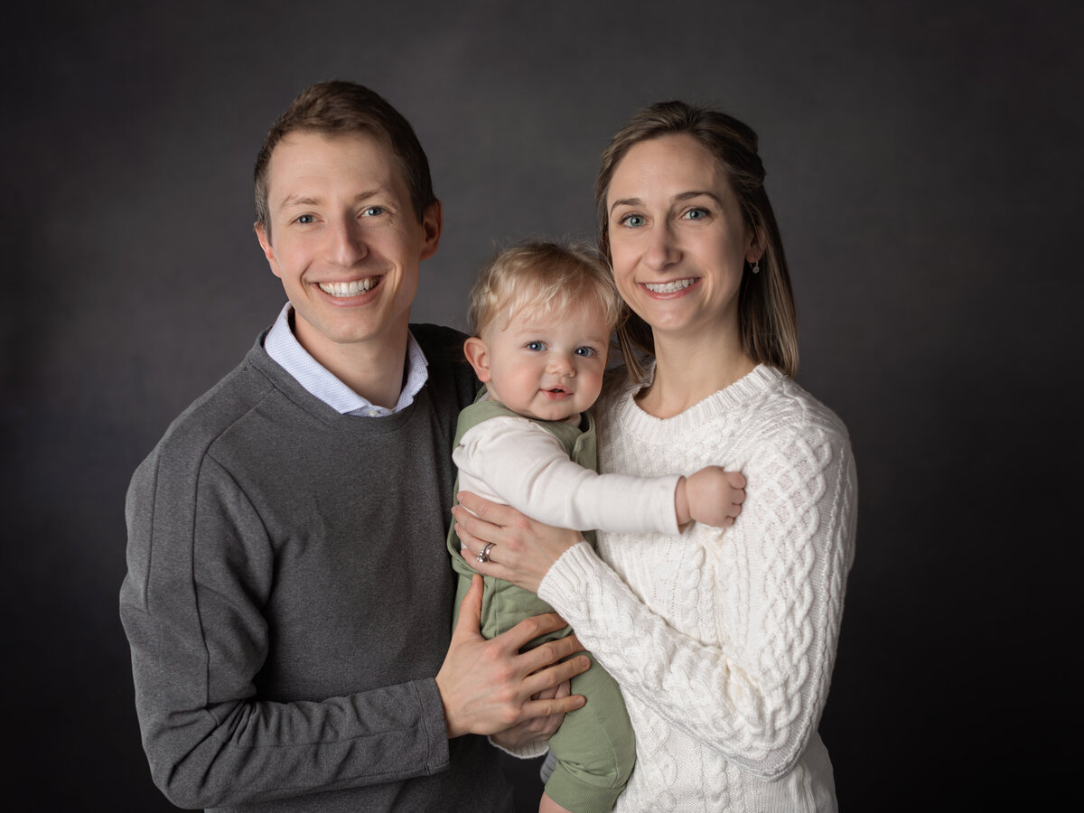 mom and dad holding son for studio portrait