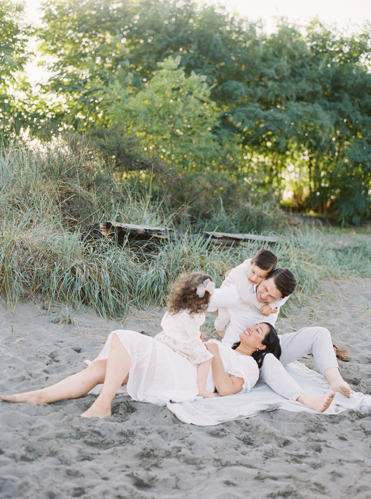 Family Photos Seattle on the beach at golden gardens. Family all wearing white and gray in the golden hour light