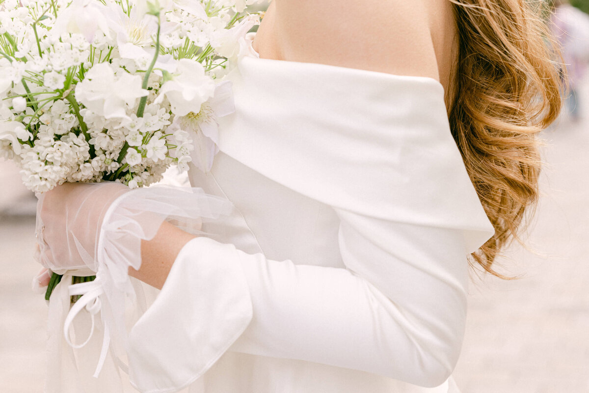 A wedding photo of the bride in her white wedding dress holding her white bouquet of flowers in London
