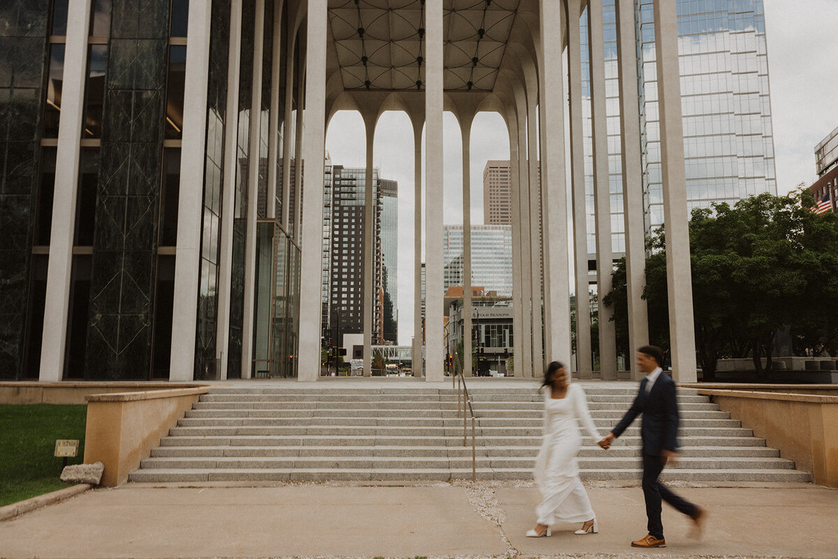 Bride and groom walk hand in hand through downtown Minneapolis