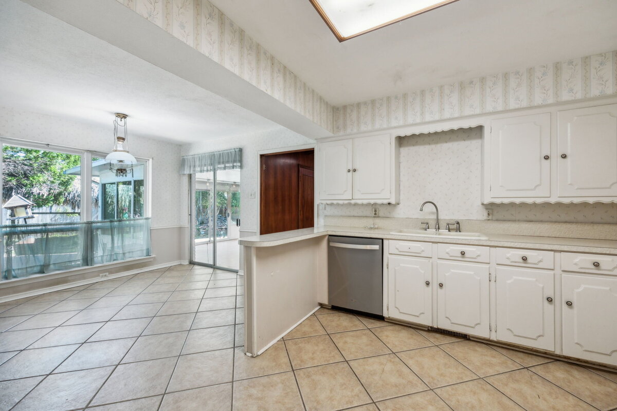 14214_edgecrest_dr_dallas_tx_kitchen_breakfast_area_-white_cabinets_tile_floor_and_backyard_view-_haven_realty_group
