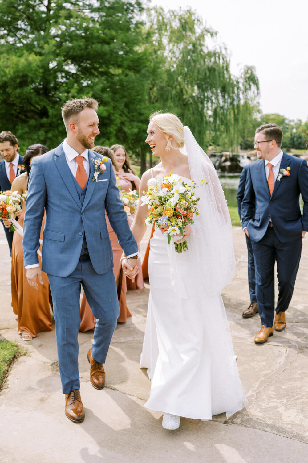 couple-walking-in-front-of-wedding-party