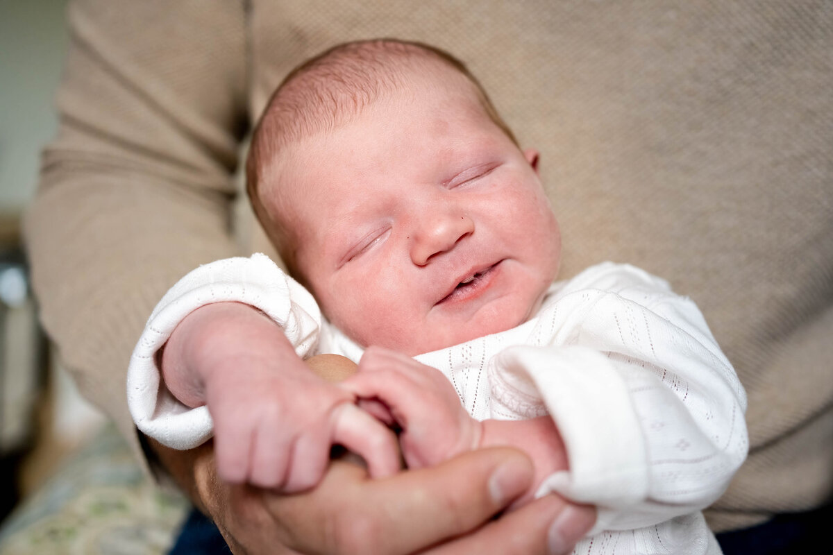 infant sleeping in Dad's arms