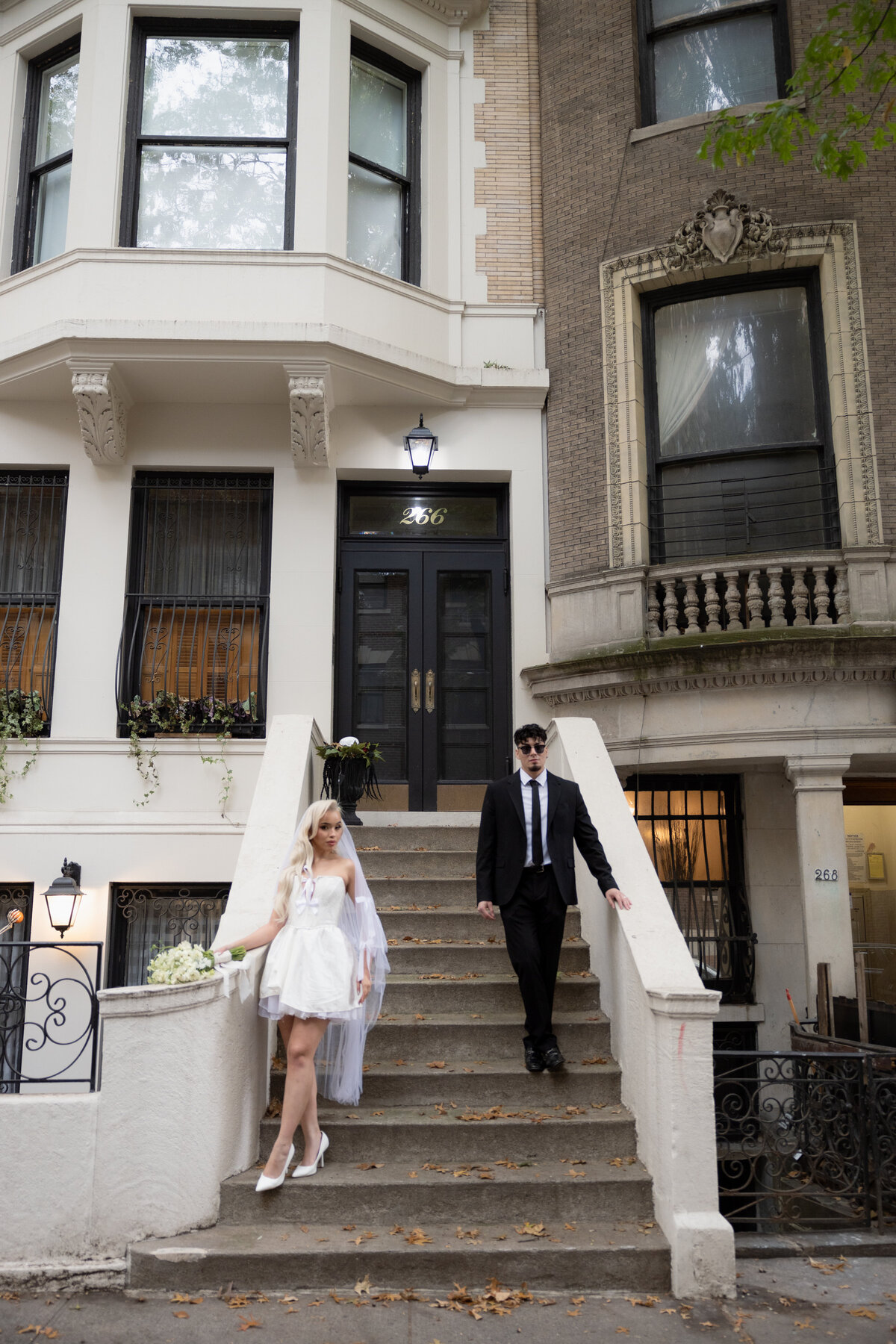 Couple sharing a quiet moment on a NYC step surrounded by city life.