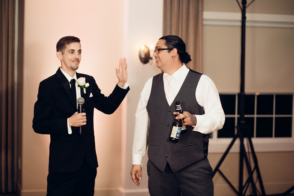 Wedding Photograph Of Groom Raising His Hand To A Man In Gray Suit Los Angeles