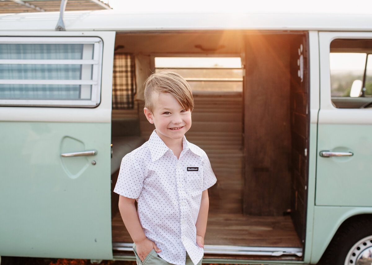 young boy sitting aginst the shuttterbus in colorado