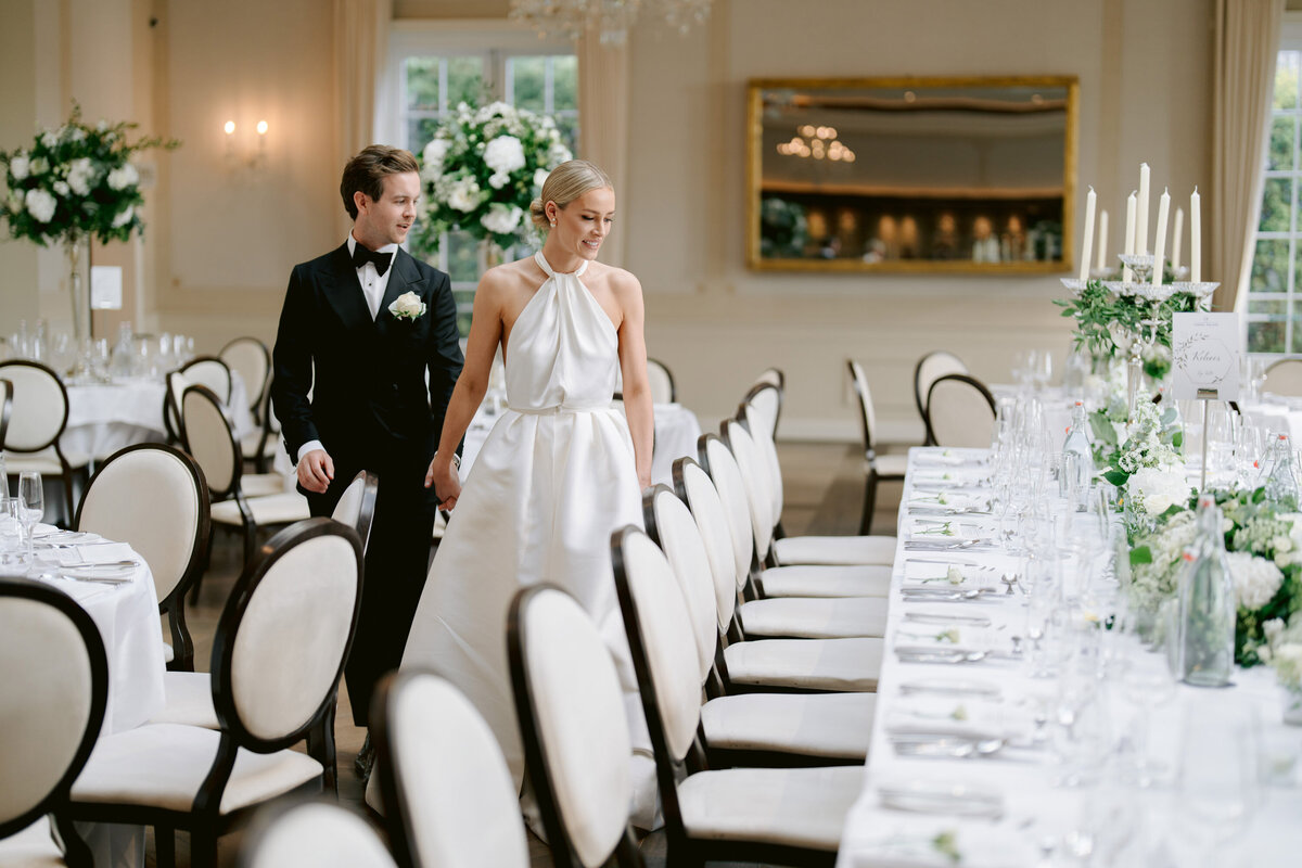 bride and groom looking at the tables at cashel palace in the ballroom