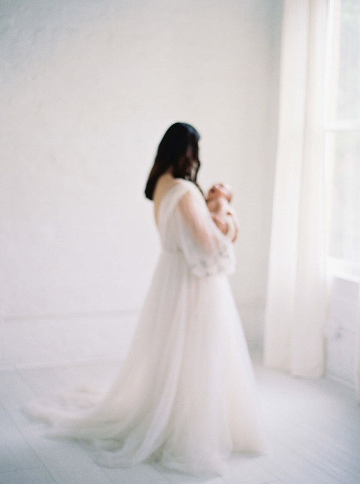 Mother cradling newborn during intimate Bay Area newborn photography session.