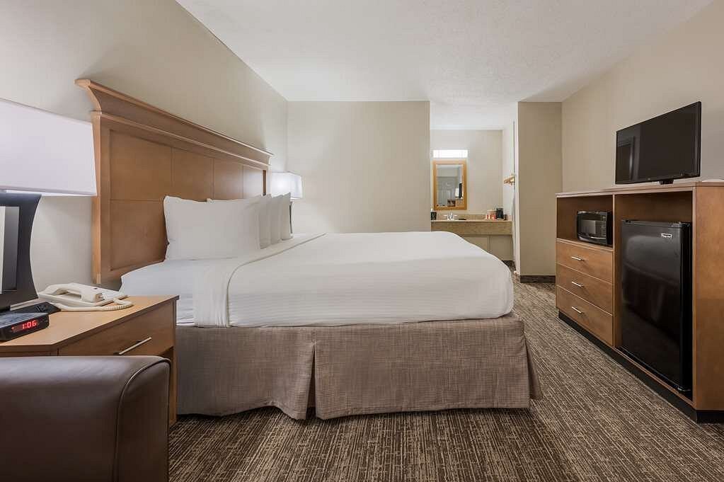 Hotel king size bed in guest room with beige accents