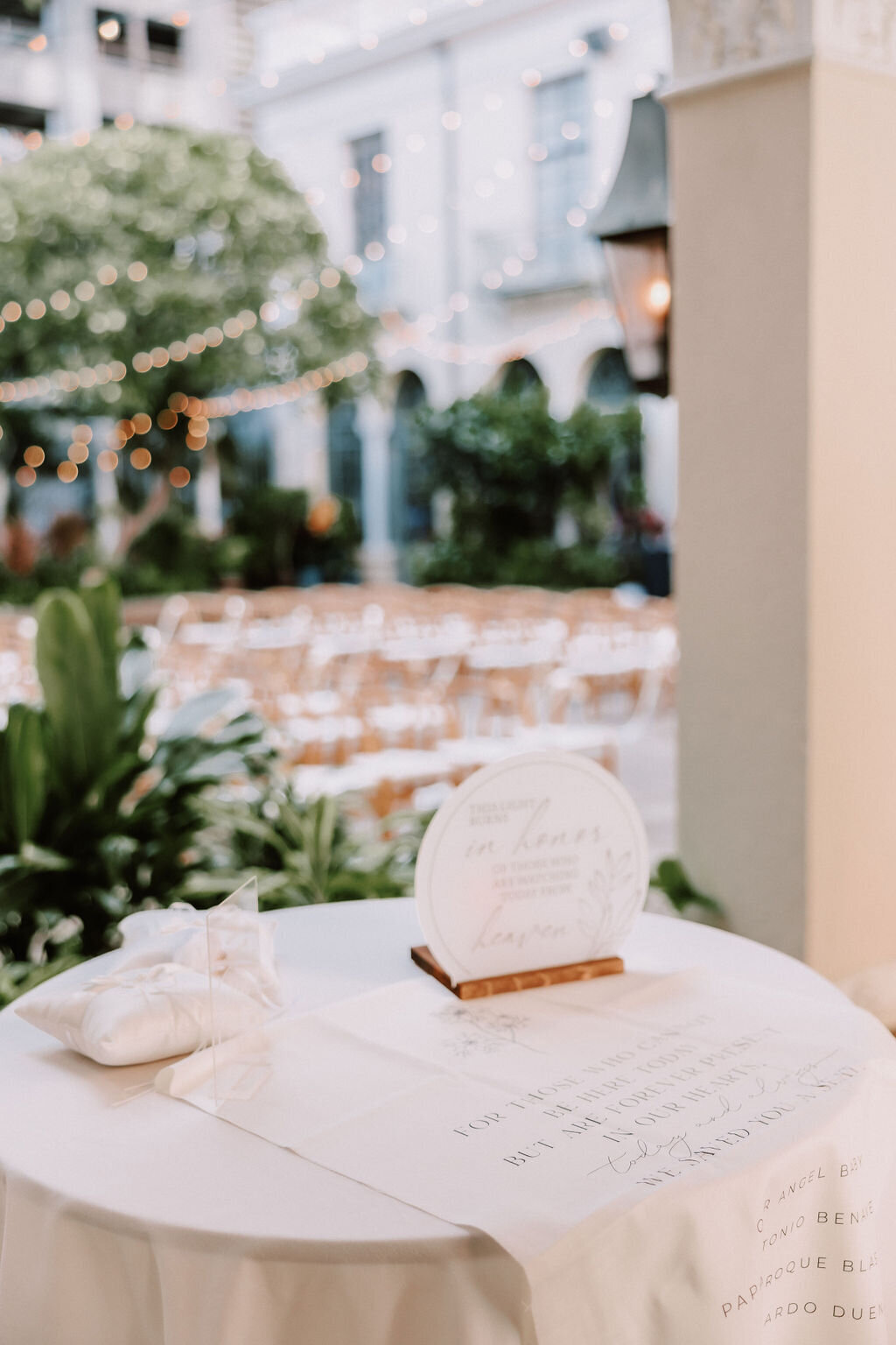 table with various signs on it and ceremony chairs in the background with european architecture