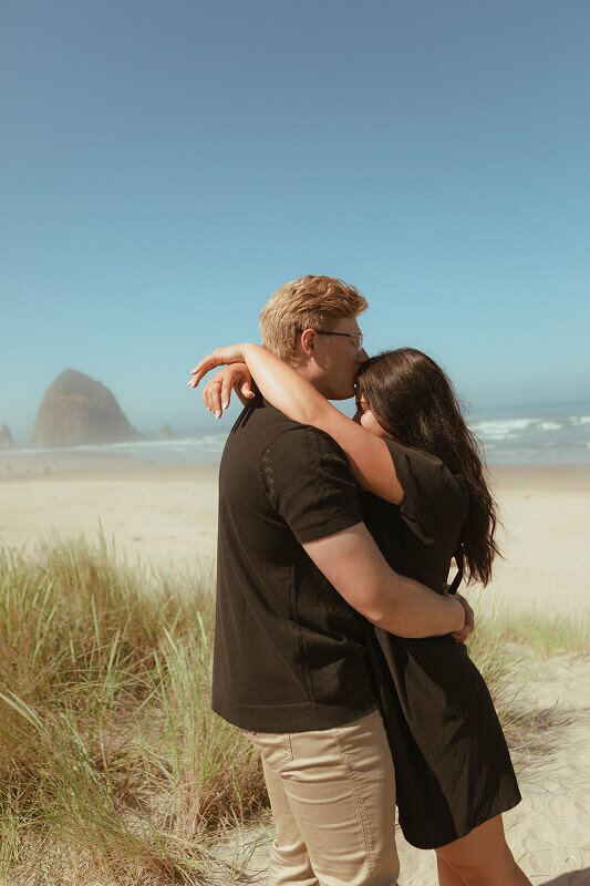 A man kisses his fiancé on the forehead during an engagement shoot with Brittney Ann Photography.