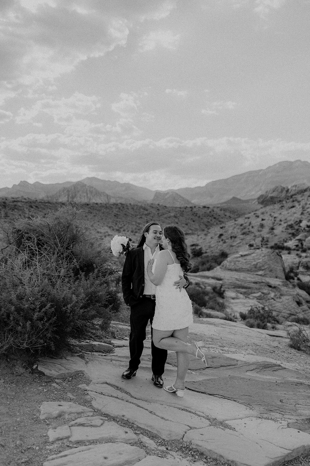 Black and white image of engaged couple smiling at the Red Rock Canyon
