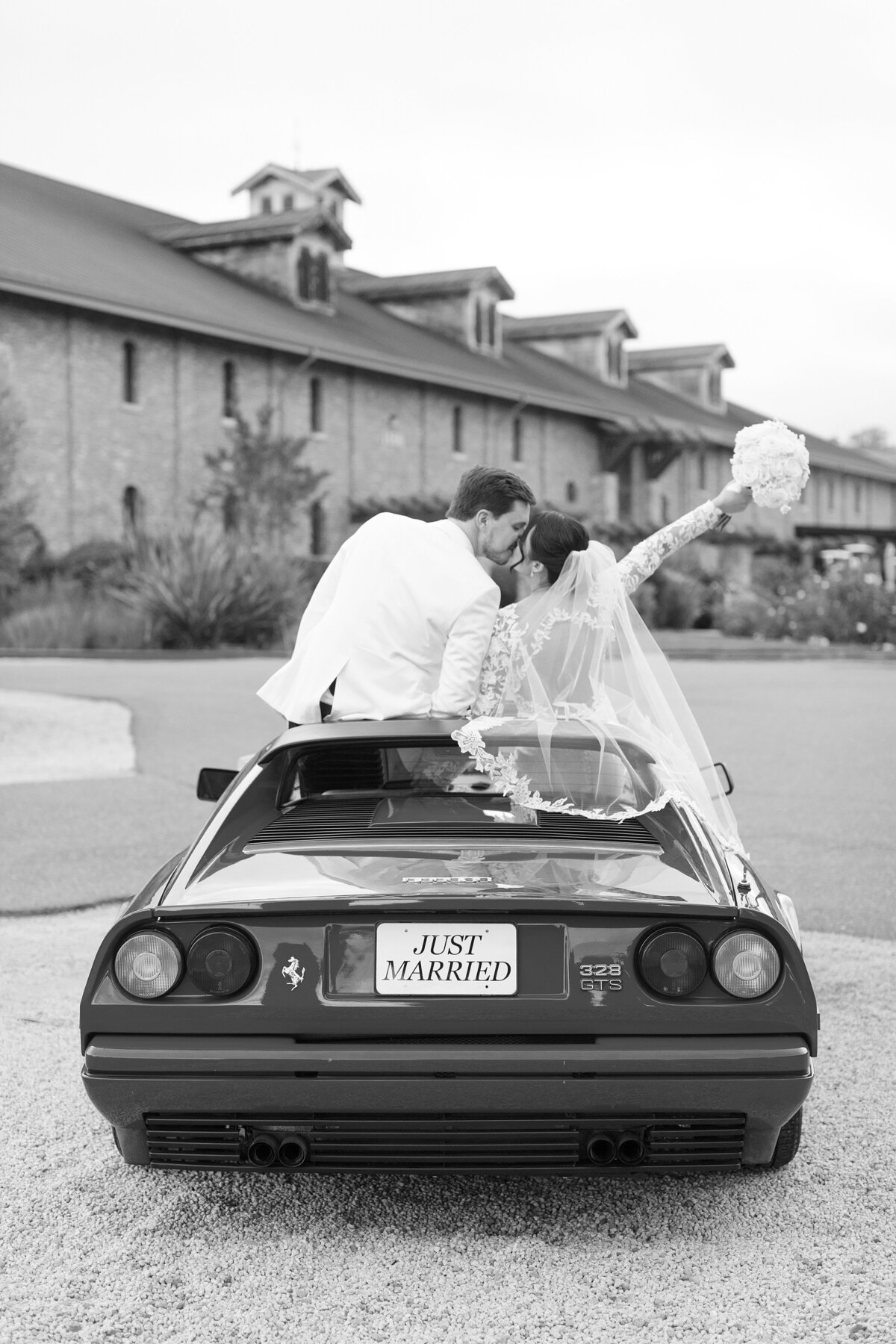 bride and groom kiss in ferrari convertible sportscar