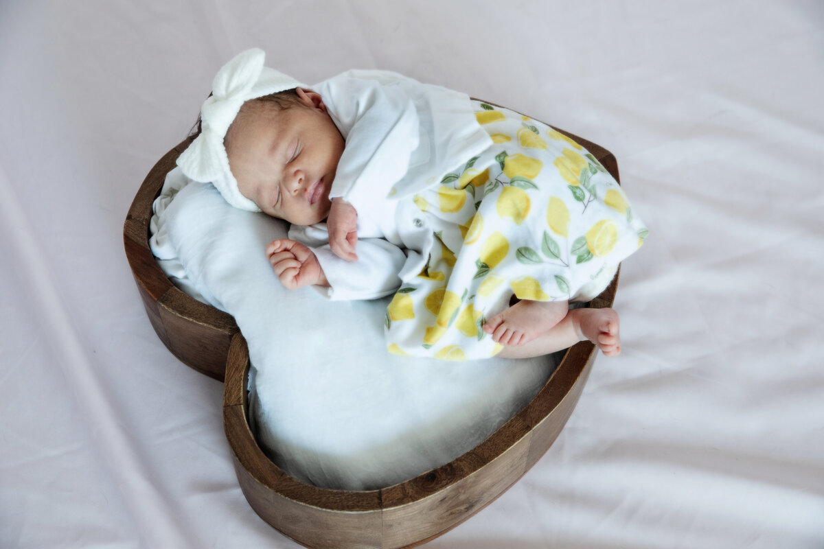 newborn baby girl in wooden heart