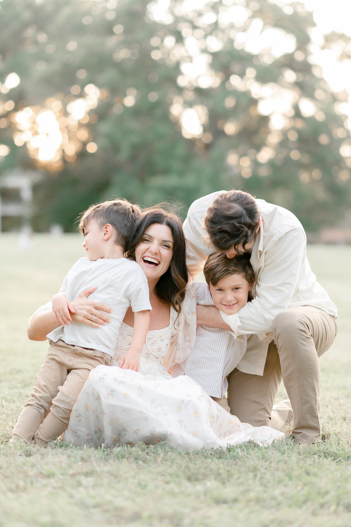 Family plays together in a yard a sunset