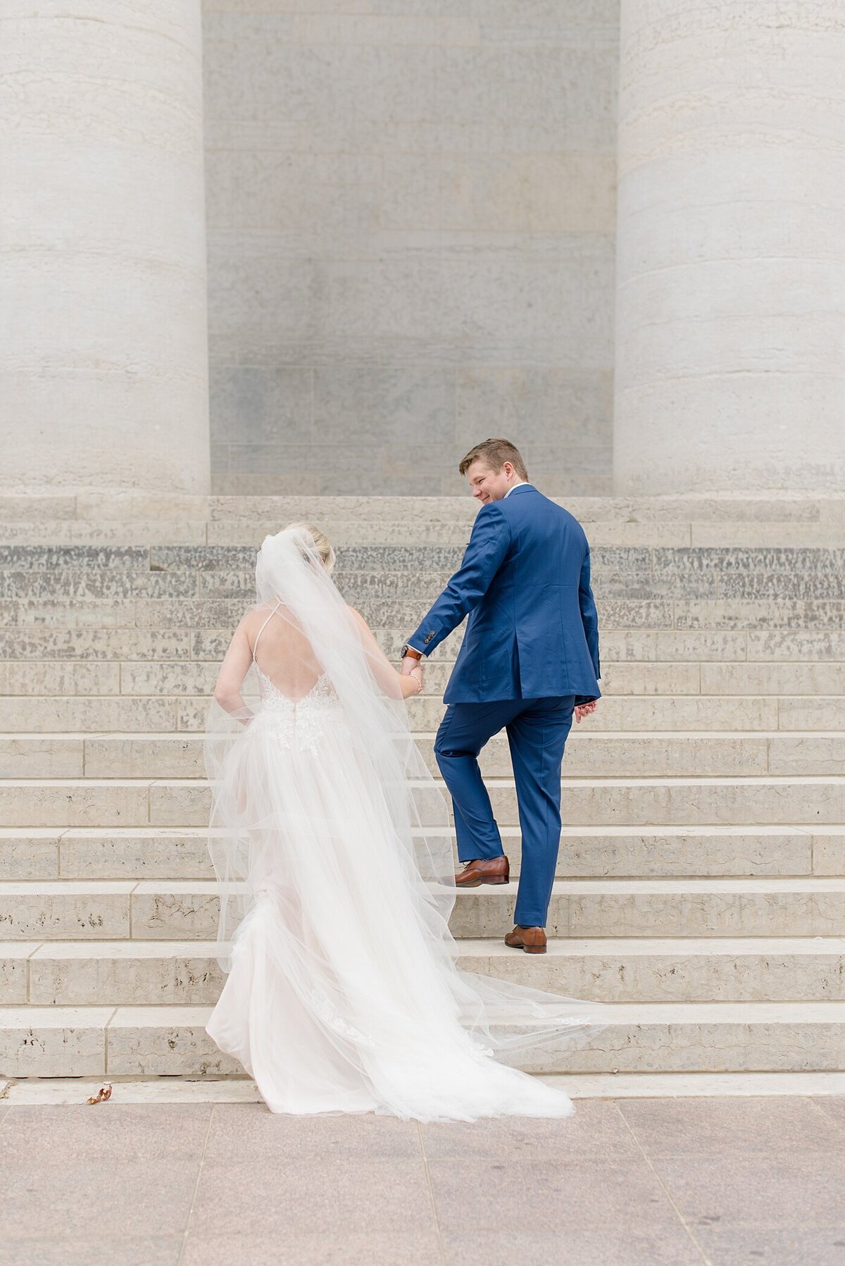 Groom leading Bride up the stairs at Ohio State House in Columbus, Ohio taken by Ohio Wedding Photographer