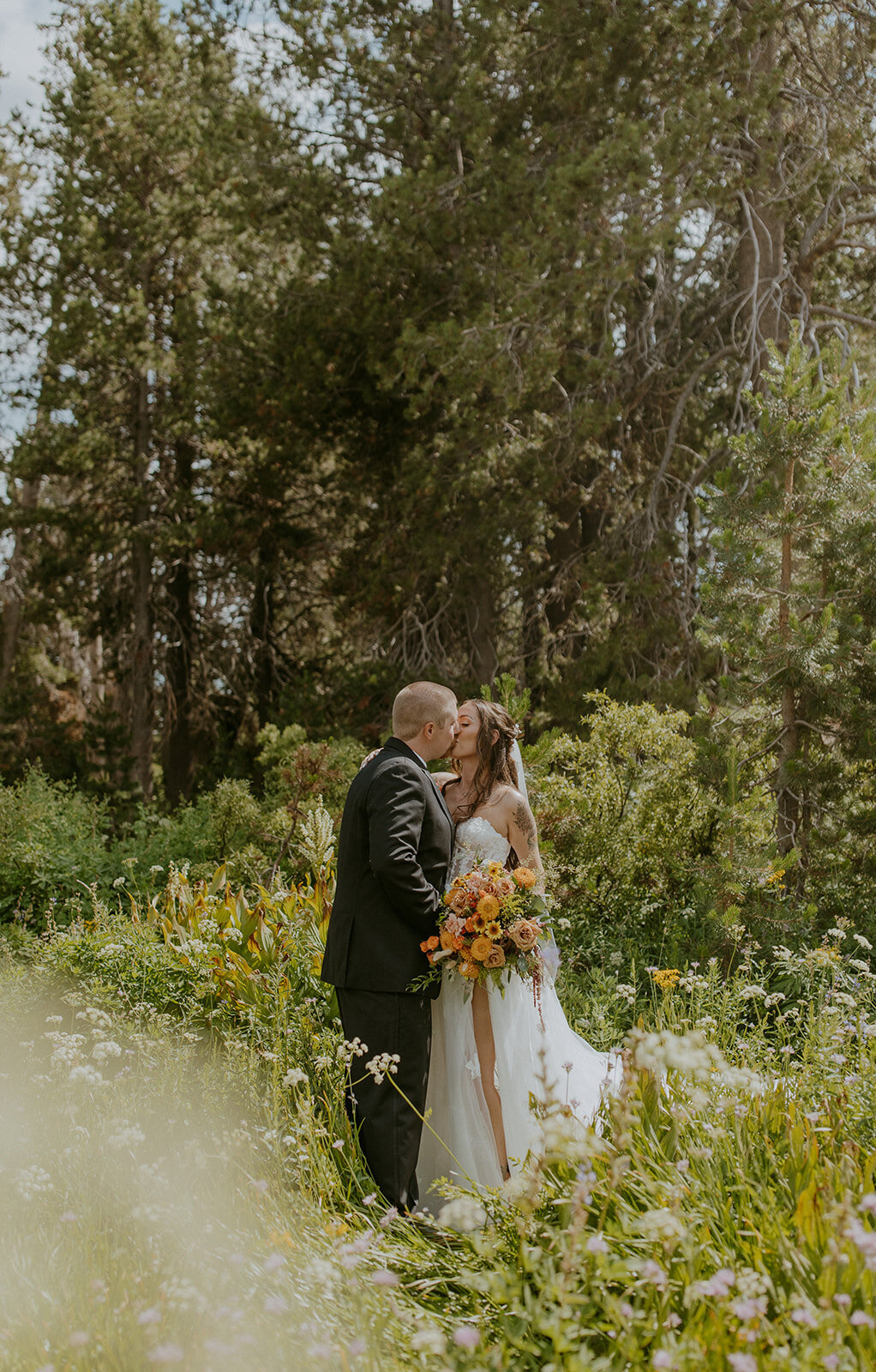 bride and groom kiss in a field of wildflowers in northern california