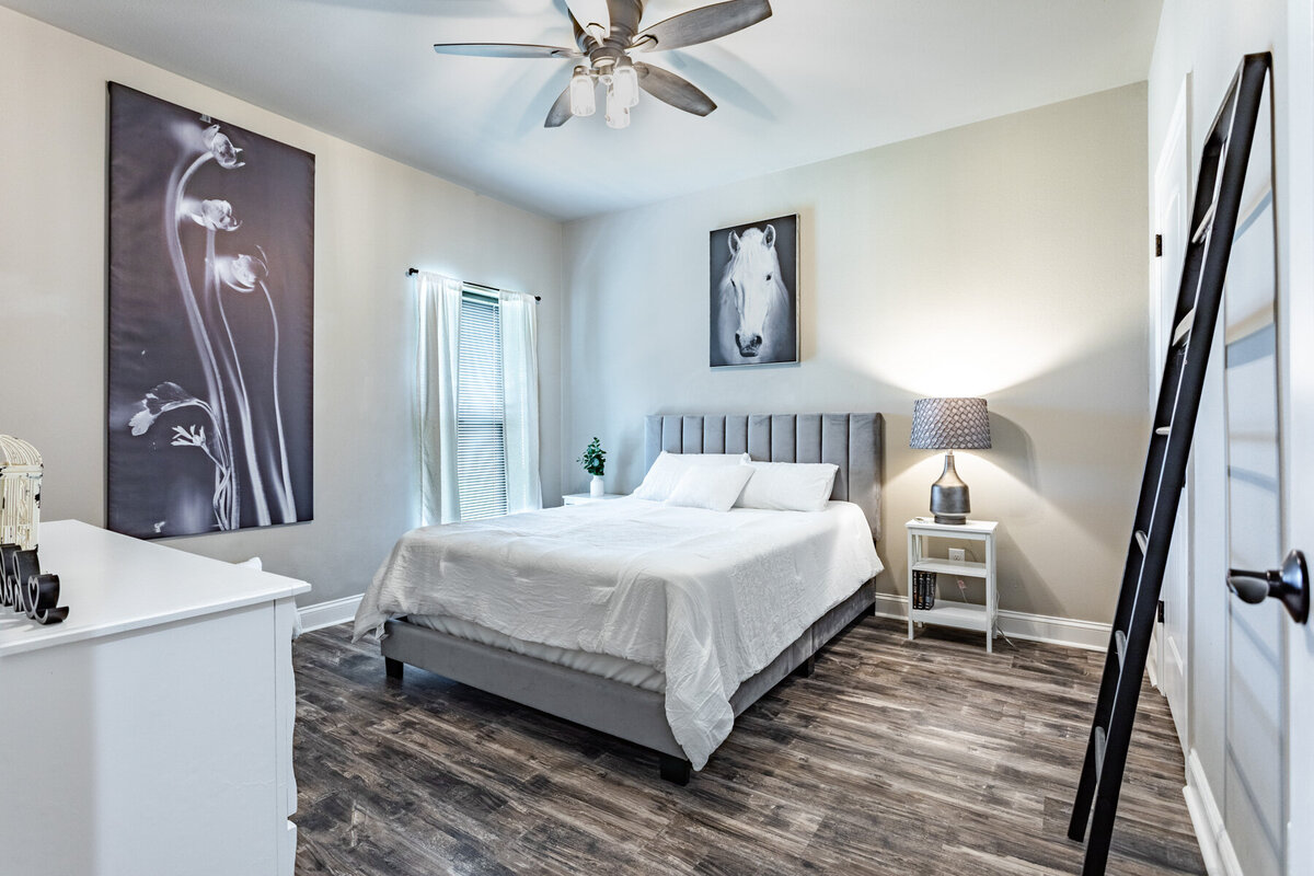 Bedroom with beautiful bedding in this five-bedroom, 3-bathroom vacation rental house for up to 10 guests with free wifi, private parking, outdoor games and seating, and bbq grill on 2 acres of land near Waco, TX.