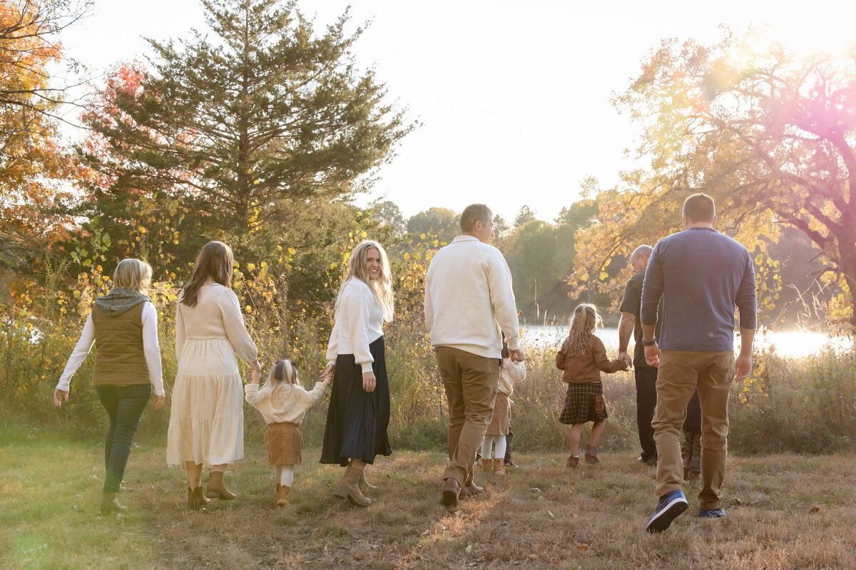 a large family walk away into the sunset in a grassy field