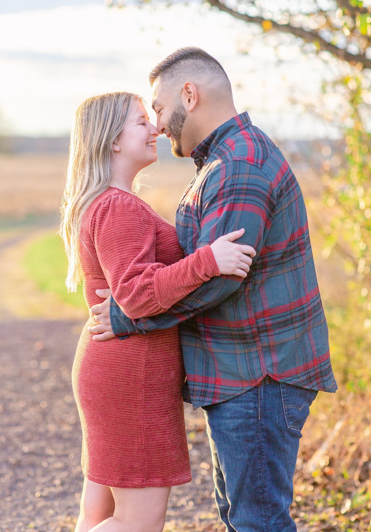 Engaged Couple nose to nose in an open field in Fredericksburg, Virginia. Captured by Bethany Aubre Photography.