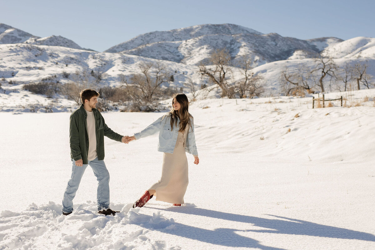 Couple walking in snowy field on vacation