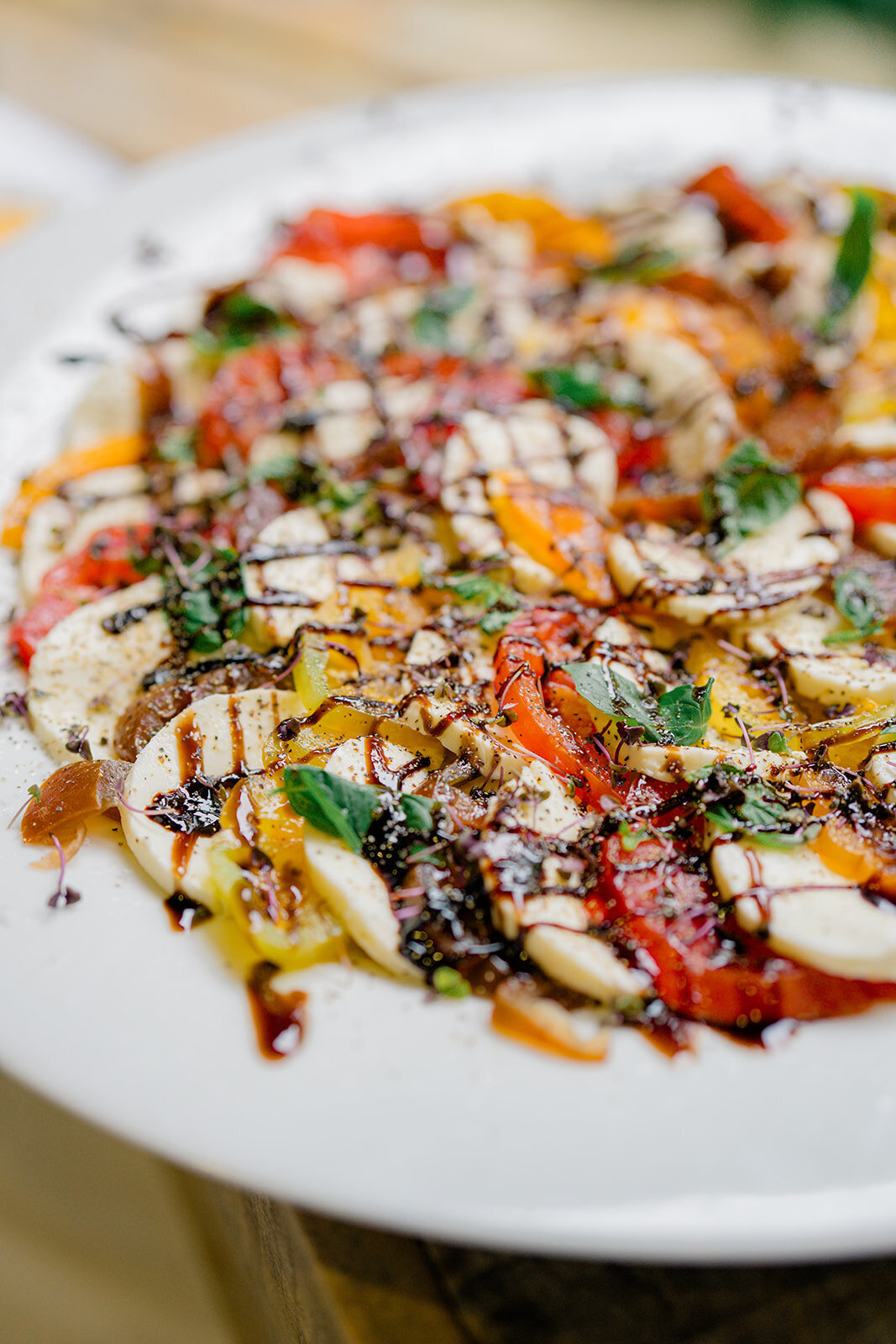 Colorful caprese salad with heirloom tomatoes, mozzarella, basil, and balsamic drizzle served at wedding reception in Highlands, NC.