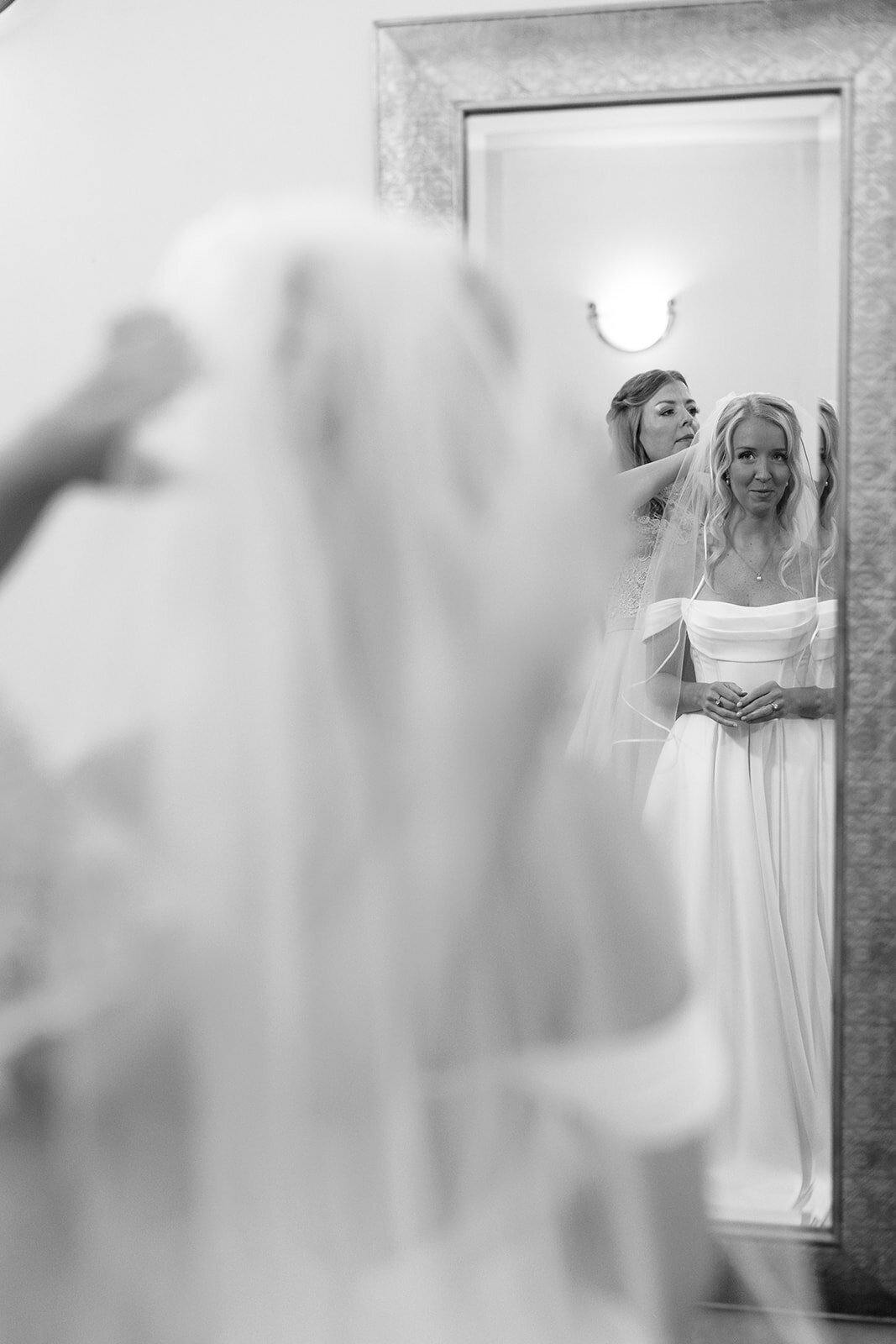 Bride putting on her veil before walking down the aisle