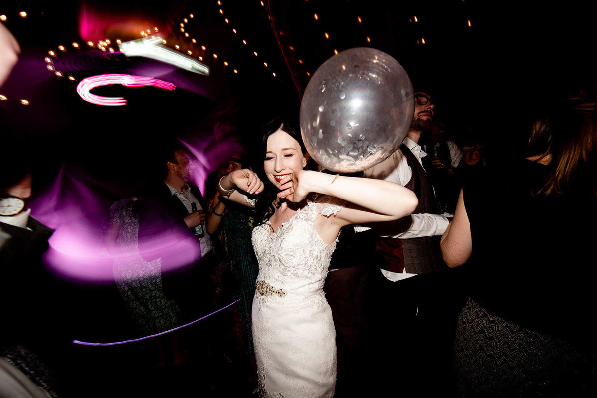 a bride throwing shapes on the dancefloor in the wedding dress