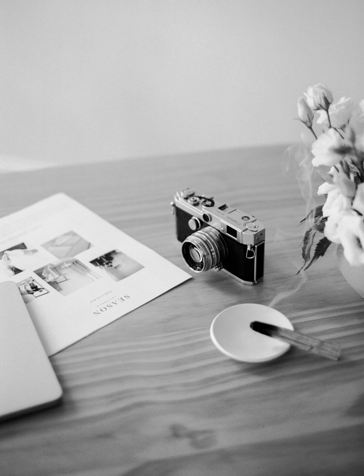 vintage film camera, vase of flowers, palo santo at desk for film branding photoshoot