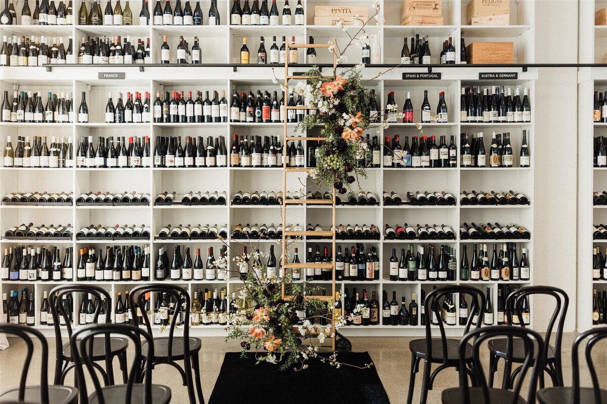 Spring floral installation on wine library ladder with tulips and grapes