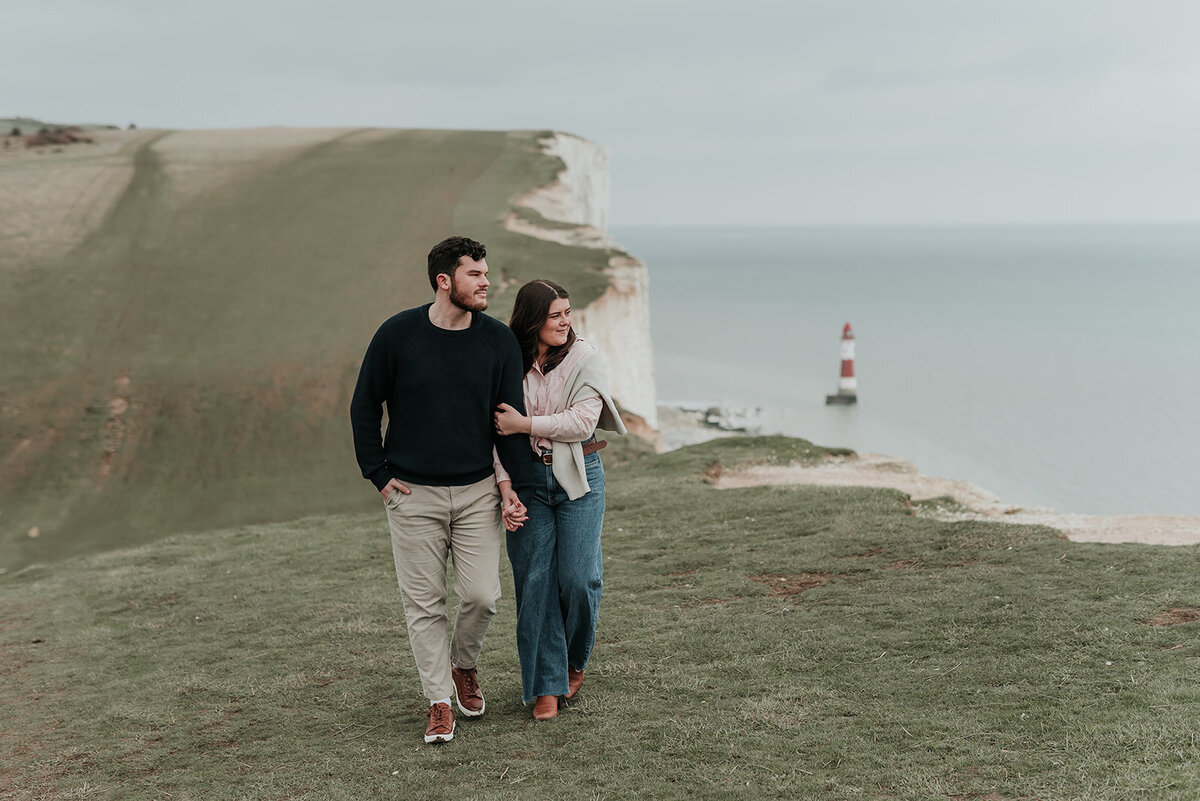 Couple looking out to sea by Eastbourne Lighthouse on Beachy Head