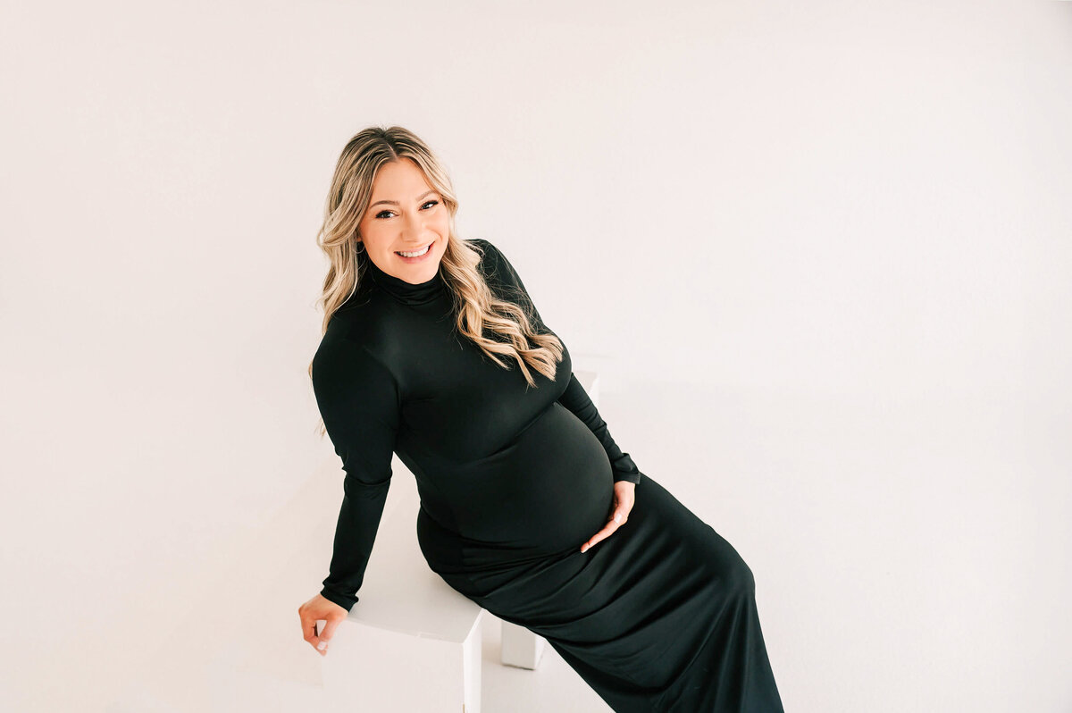 maternity picture in Springfield MO of pregnant mom sitting on white step smiling