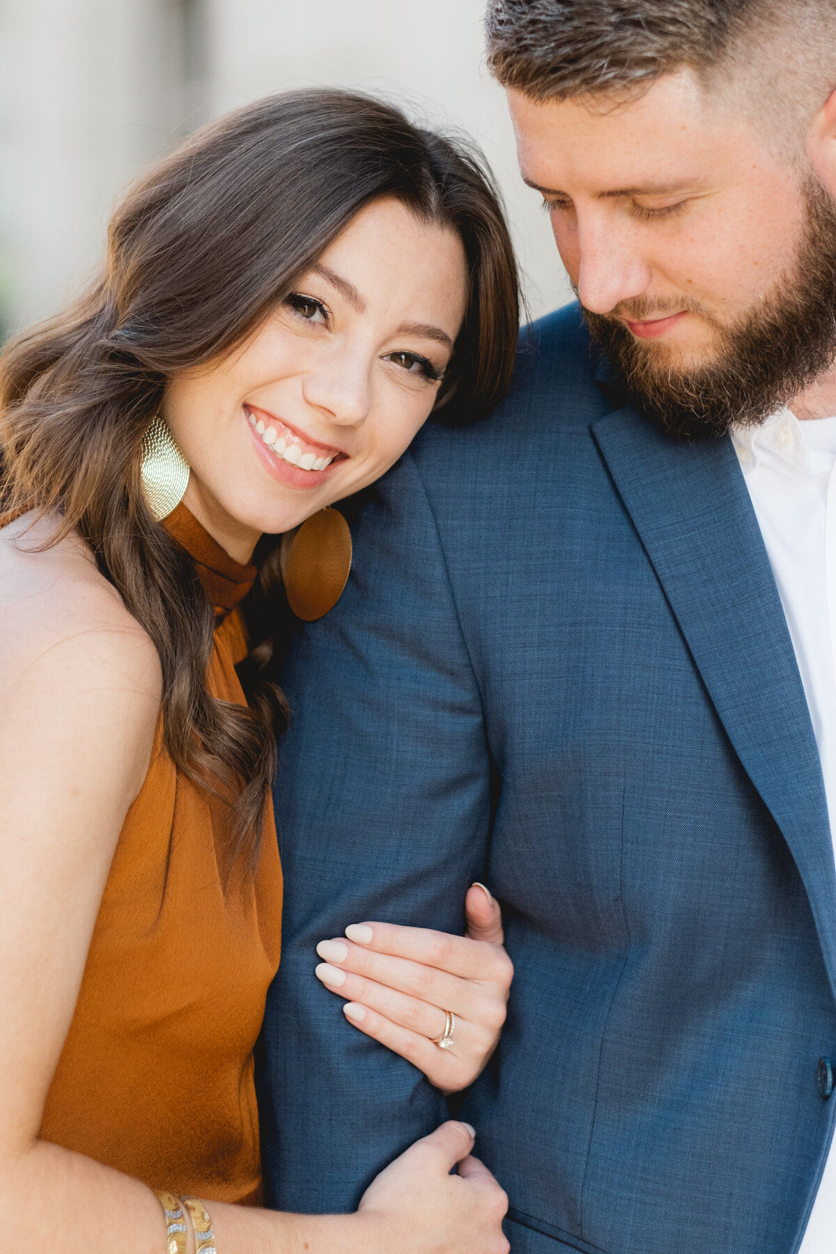 up close portrait of engagement session couple wearing orange dress and blue blazer
