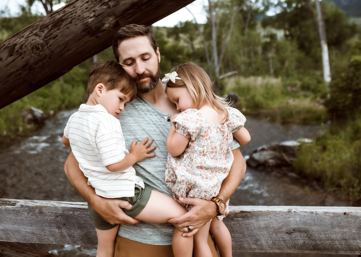 Father comforts young children during family photography session in Boulder Colorado