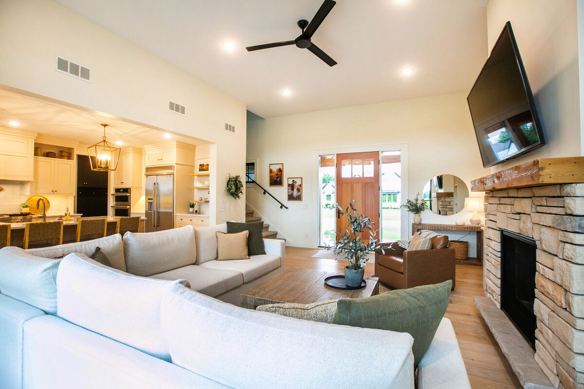 Cozy living room in Otsego custom home with fireplace, built-ins, and large windows
