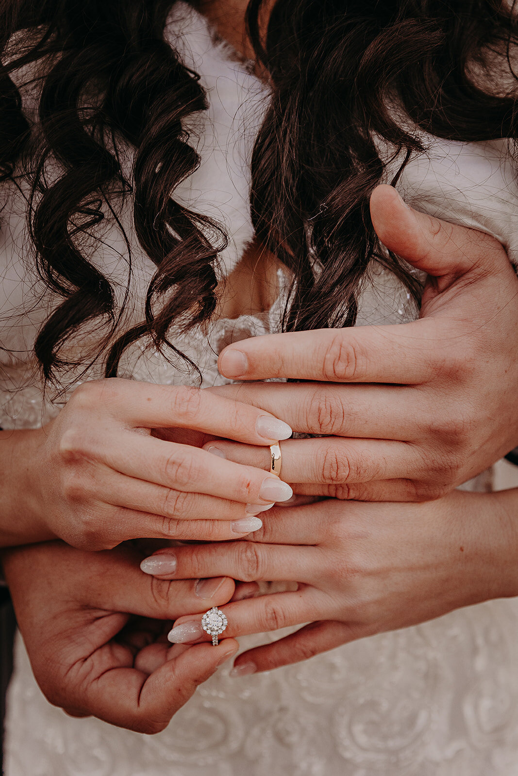 Bride and groom's hands showing wedding rings and bands.