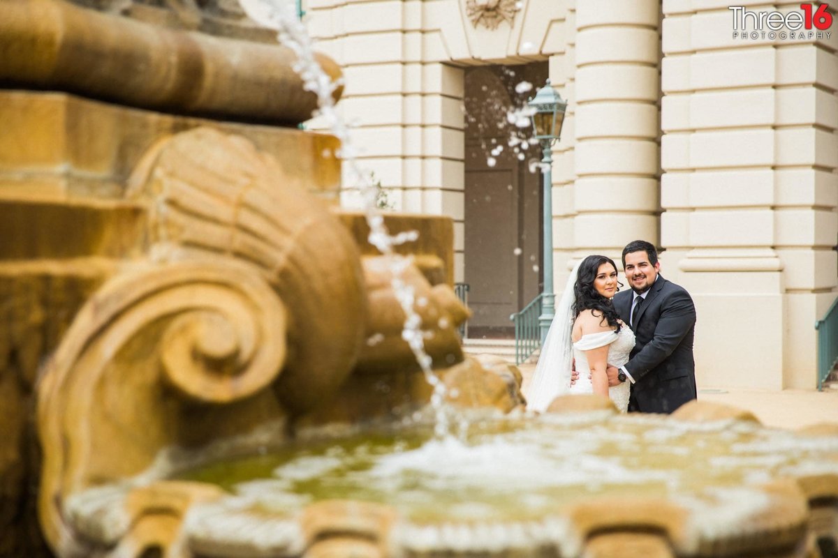 Newly married couple pose for photos behind the Pasadena City Hall water fountain