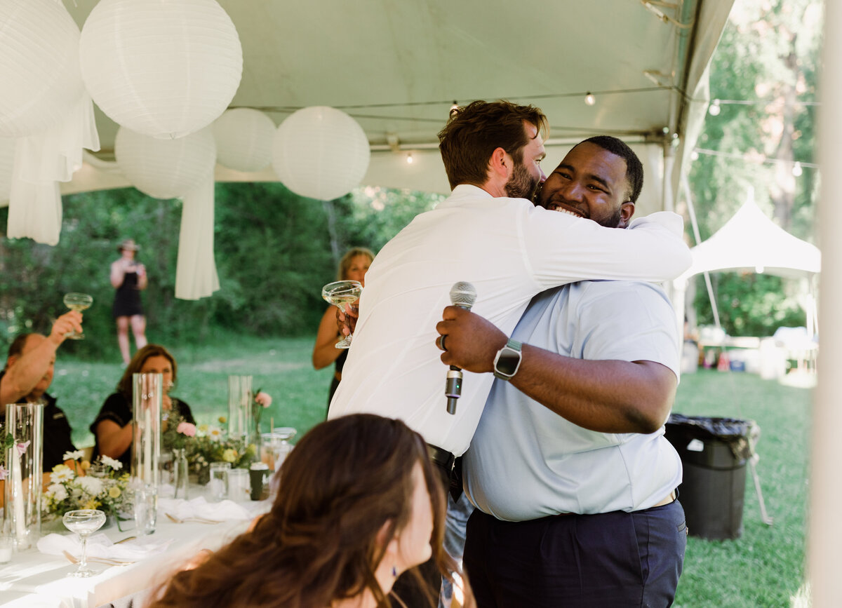 Men hugging at Dallenbach Ranch Wedding reception Colorado