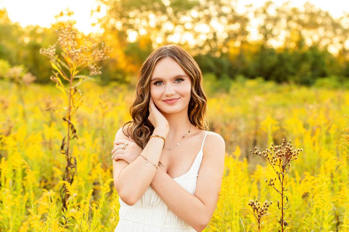 Senior girl in brush staring into camera with soft smile