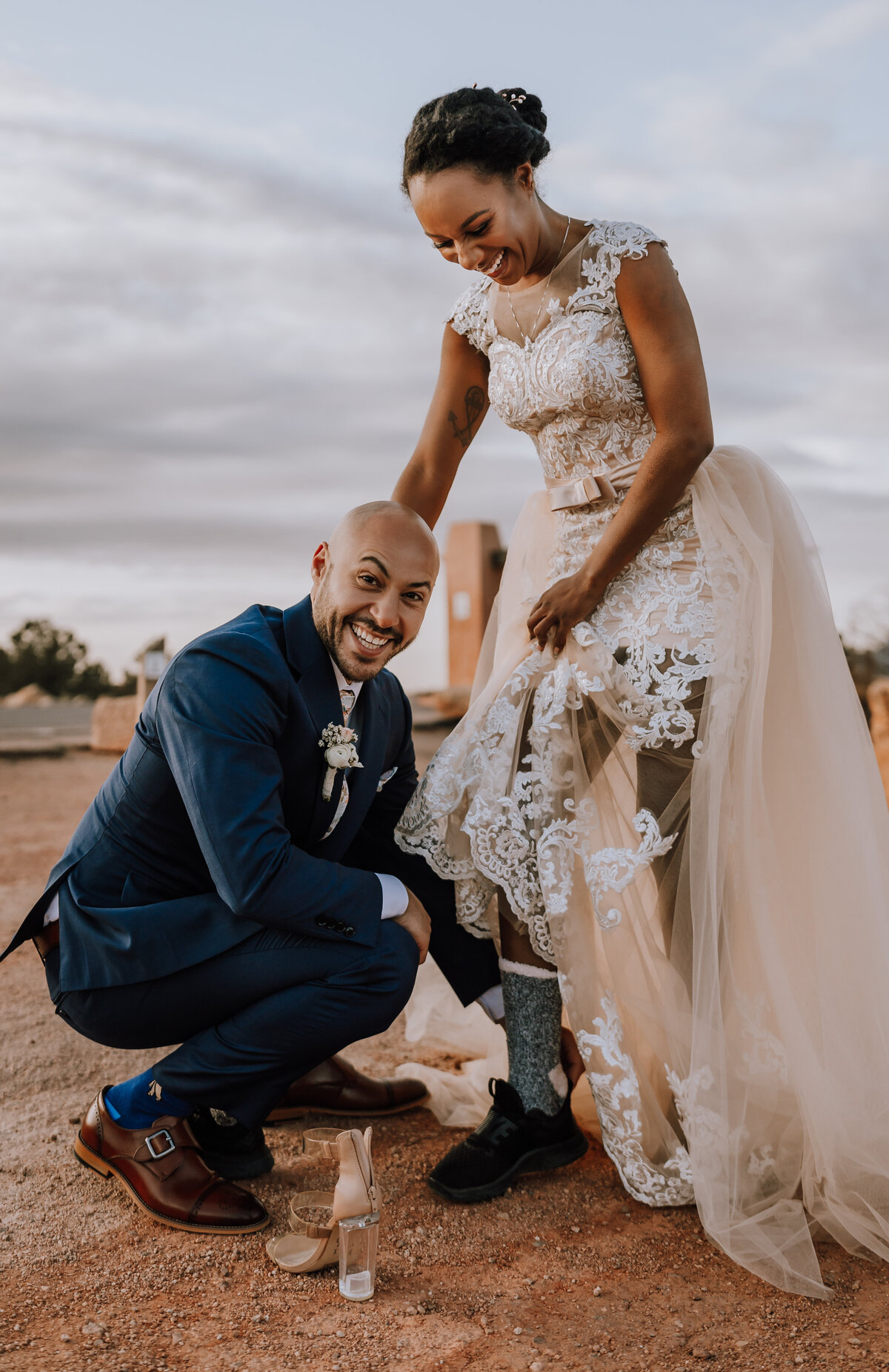 groom placing on brides hiking shoes