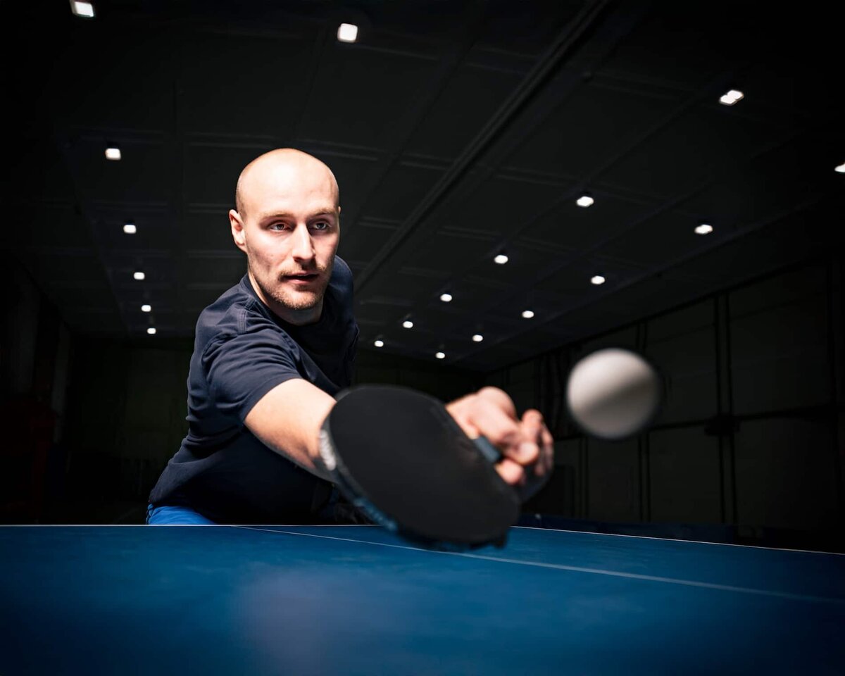 Actionbild på en bordtennisspelare som möter upp bollen.