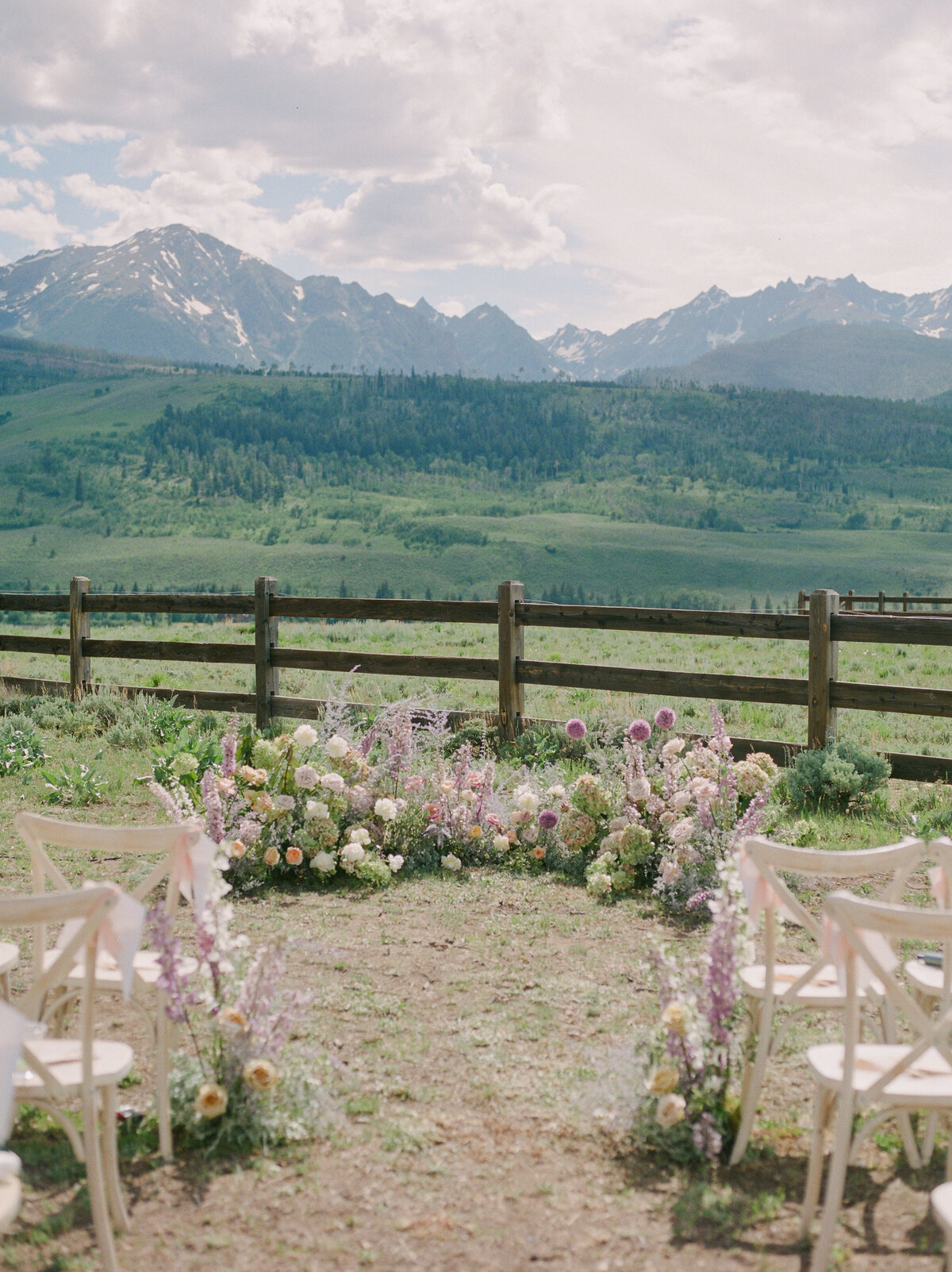 A film photograph of a pastel ceremony floral installation in the mountains of Silverthorne, Colorado