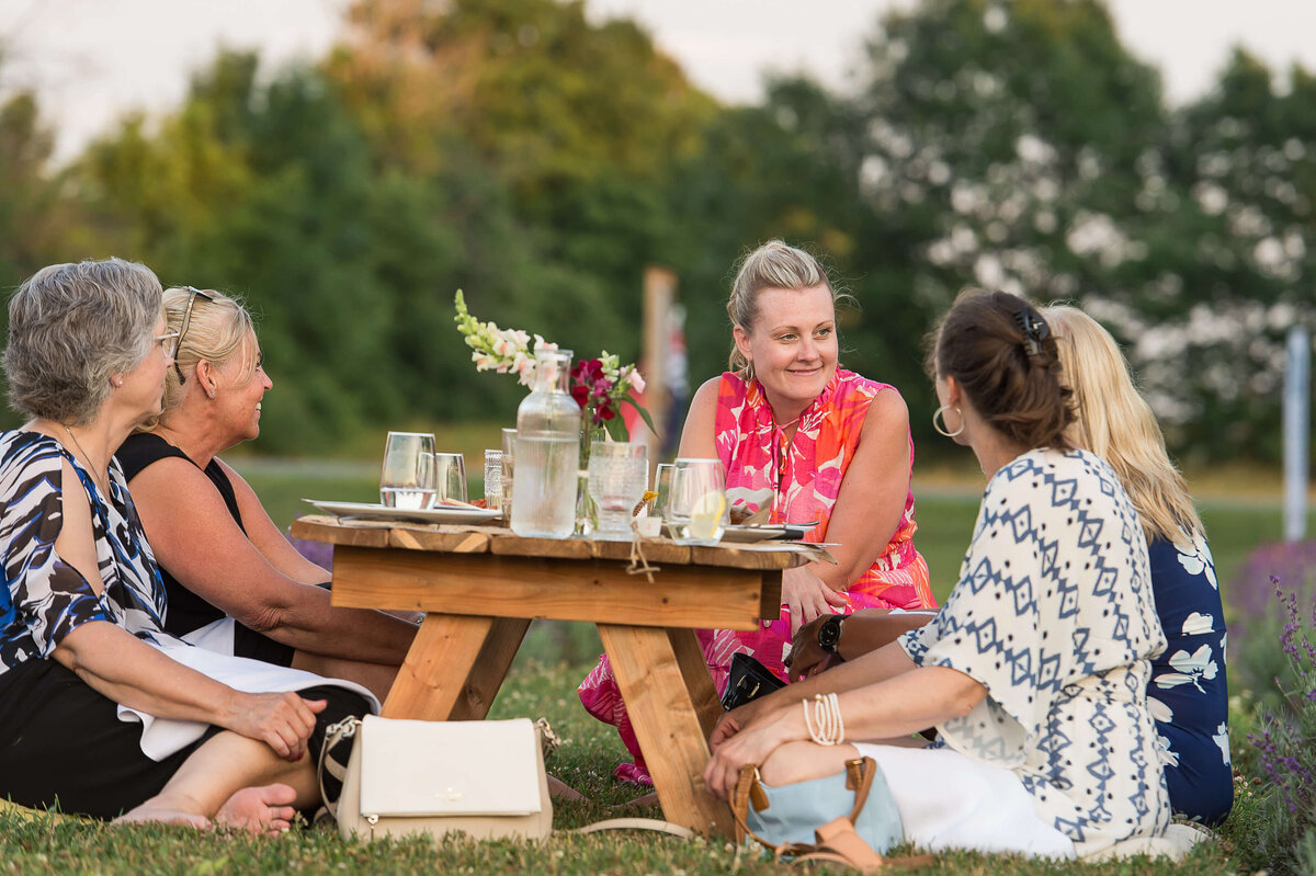 women chatting intimately with the owner of Drinks in Tow as part of Soiree in the Field.  Captured by Ottawa Event Photographer JEMMAN Photography COMMERCIAL