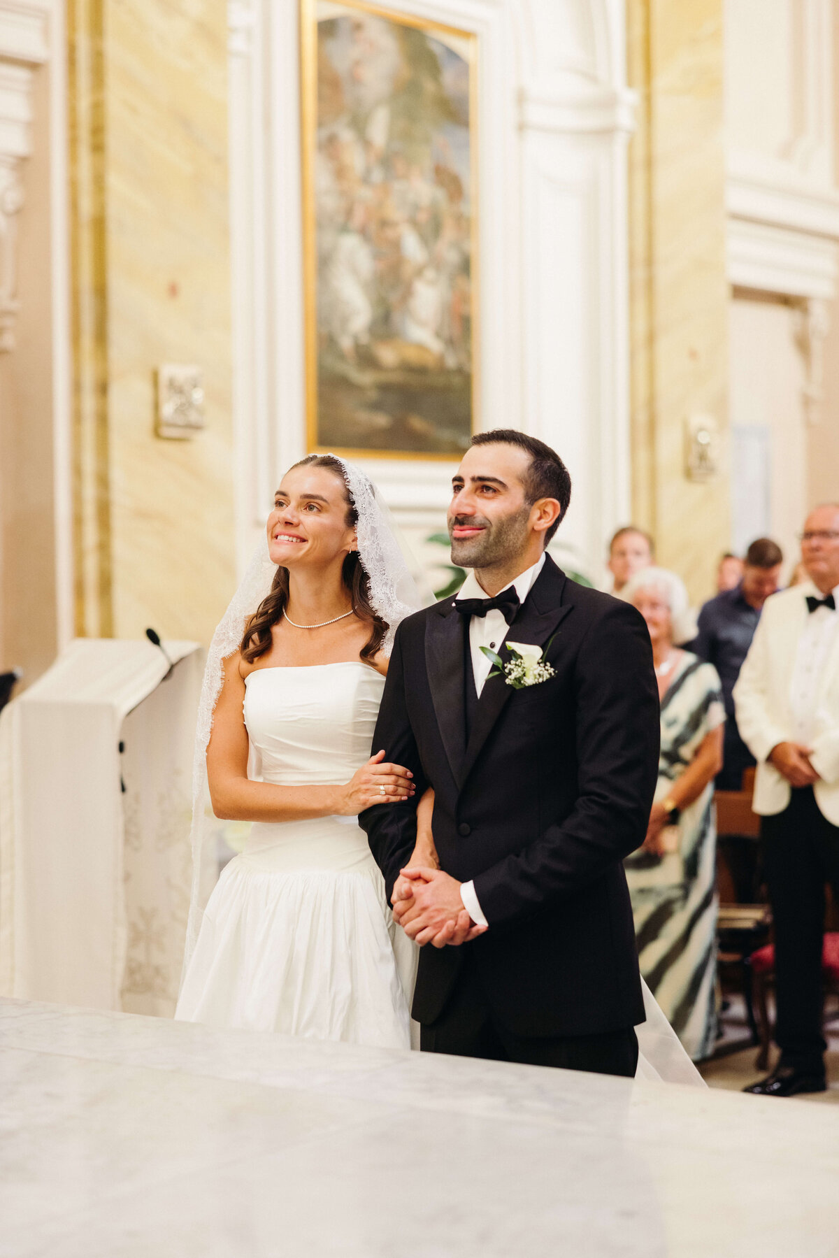 Bride smiling at groom during vows at altar in Rome church

