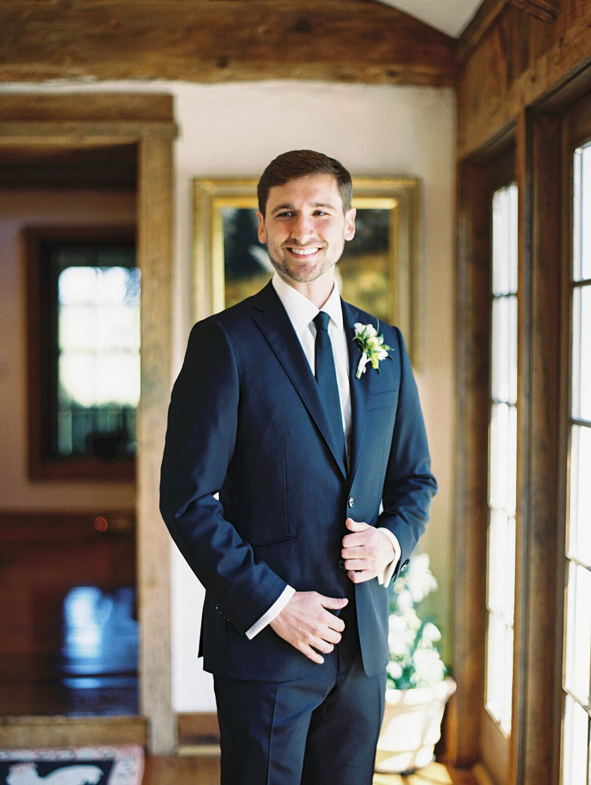 Groom happily glances at camera