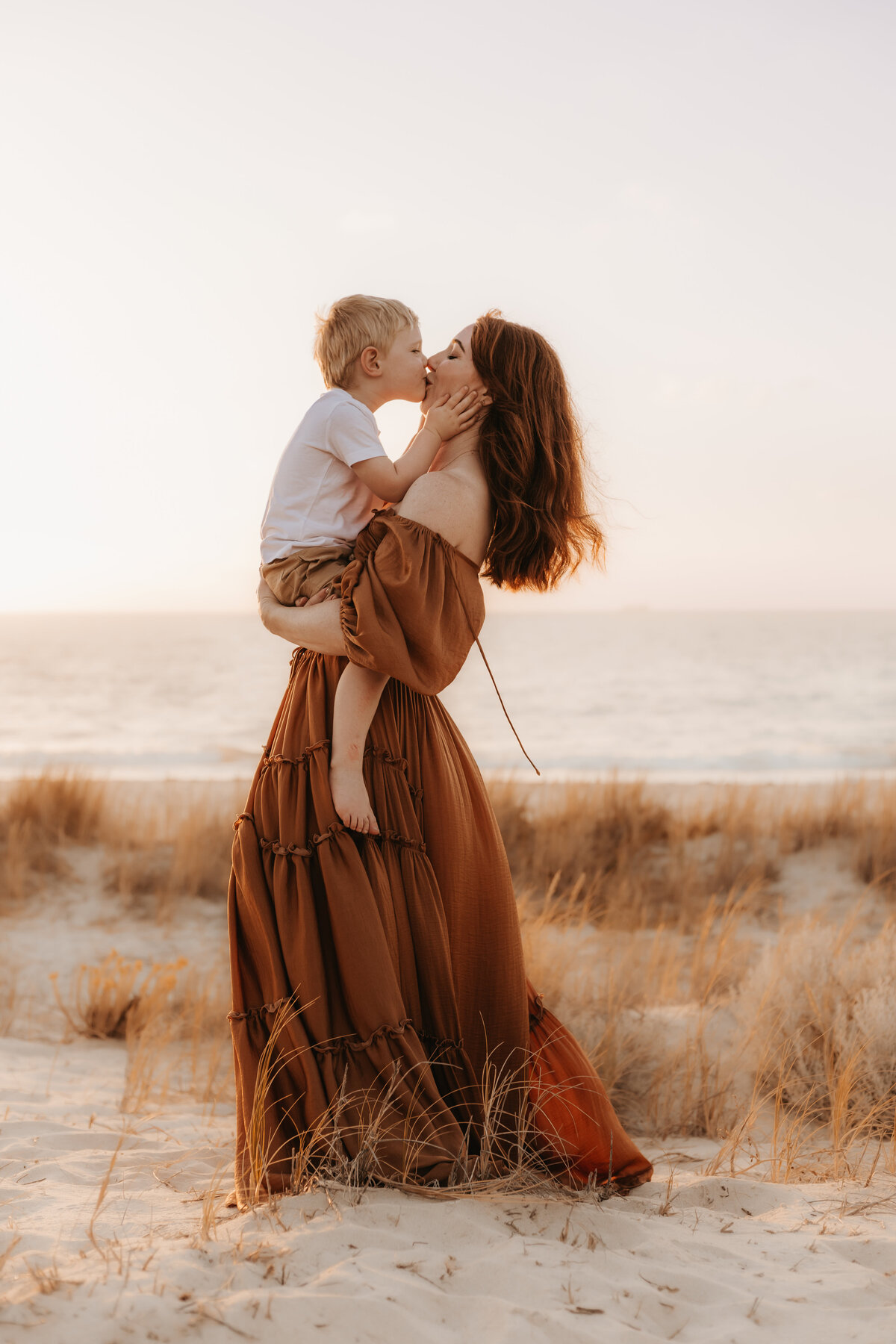 Mother and son share a kiss and cuddle at City Beach in Perth WA