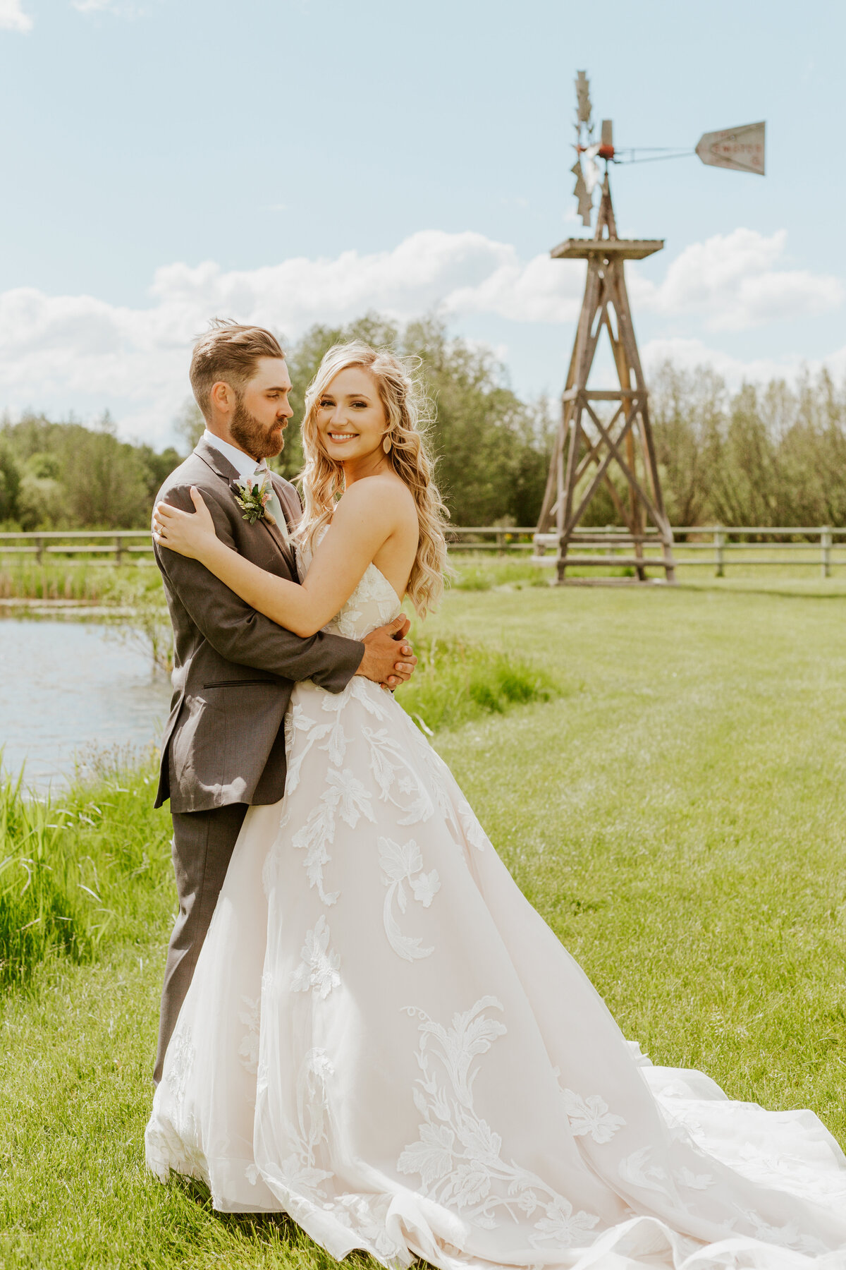 bride and groom embracing by windmill
